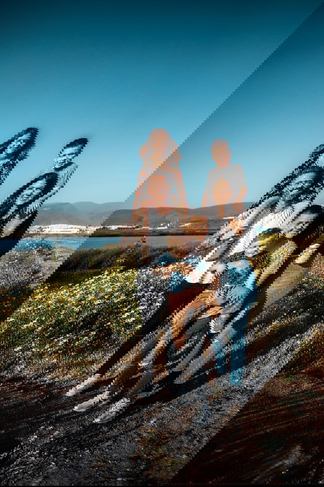 2 women and man standing on green grass field during daytime